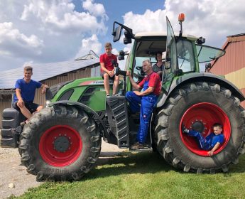 Familienfoto auf dem Traktor: Sibylle und Gerhard Kümmerer mit ihren Söhnen Luka, Fabio und Mika.